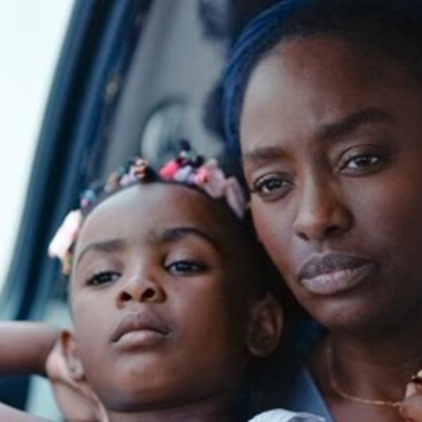 a Black woman holds her child in her lap