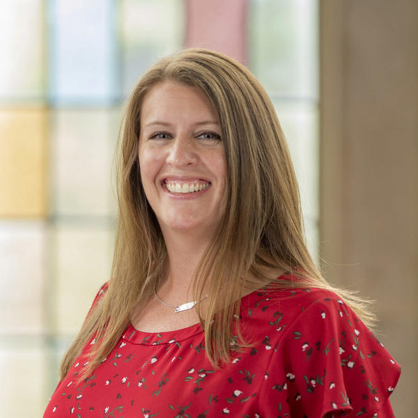 A smiling woman in a red shirt.