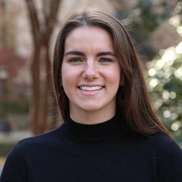 A young woman smiles into the camera.