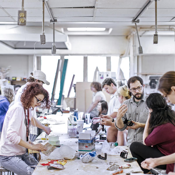 students gather around a table to do projects