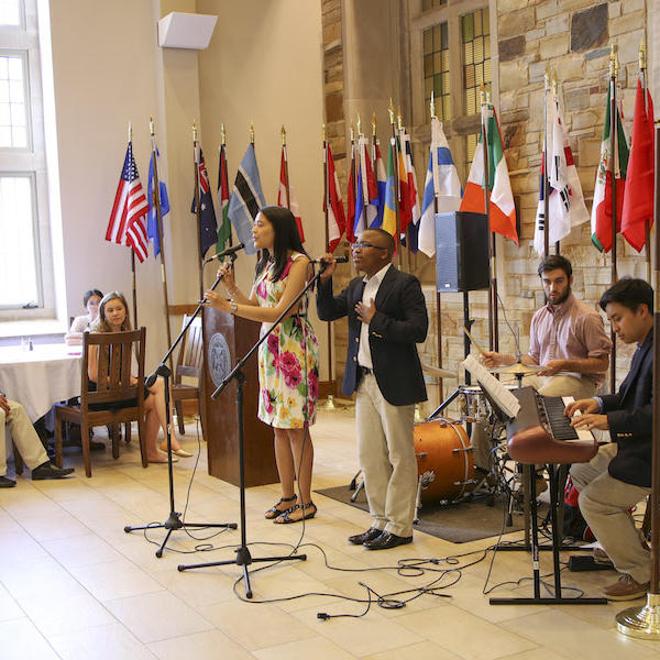 Students playing music in front of an assortment of flags