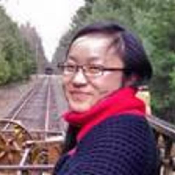 Portrait of Shaolu Yu in front of train tracks surrounded by trees