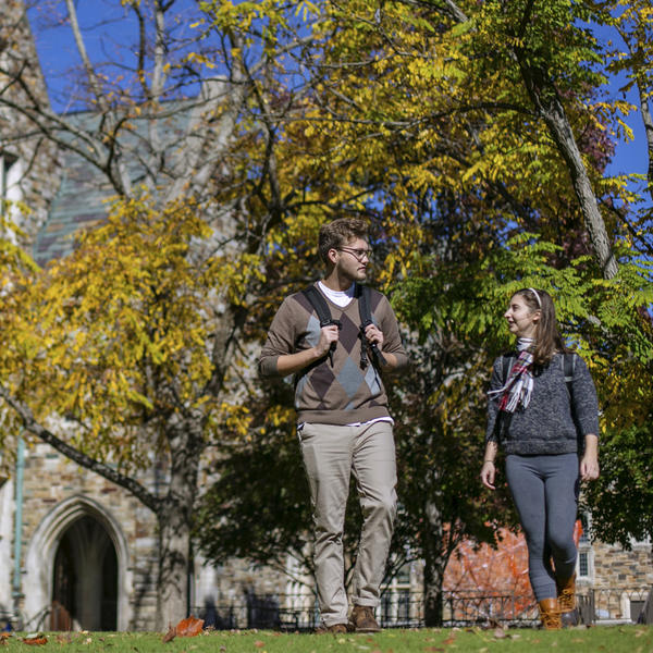 two students walking outside on a sunny fall day