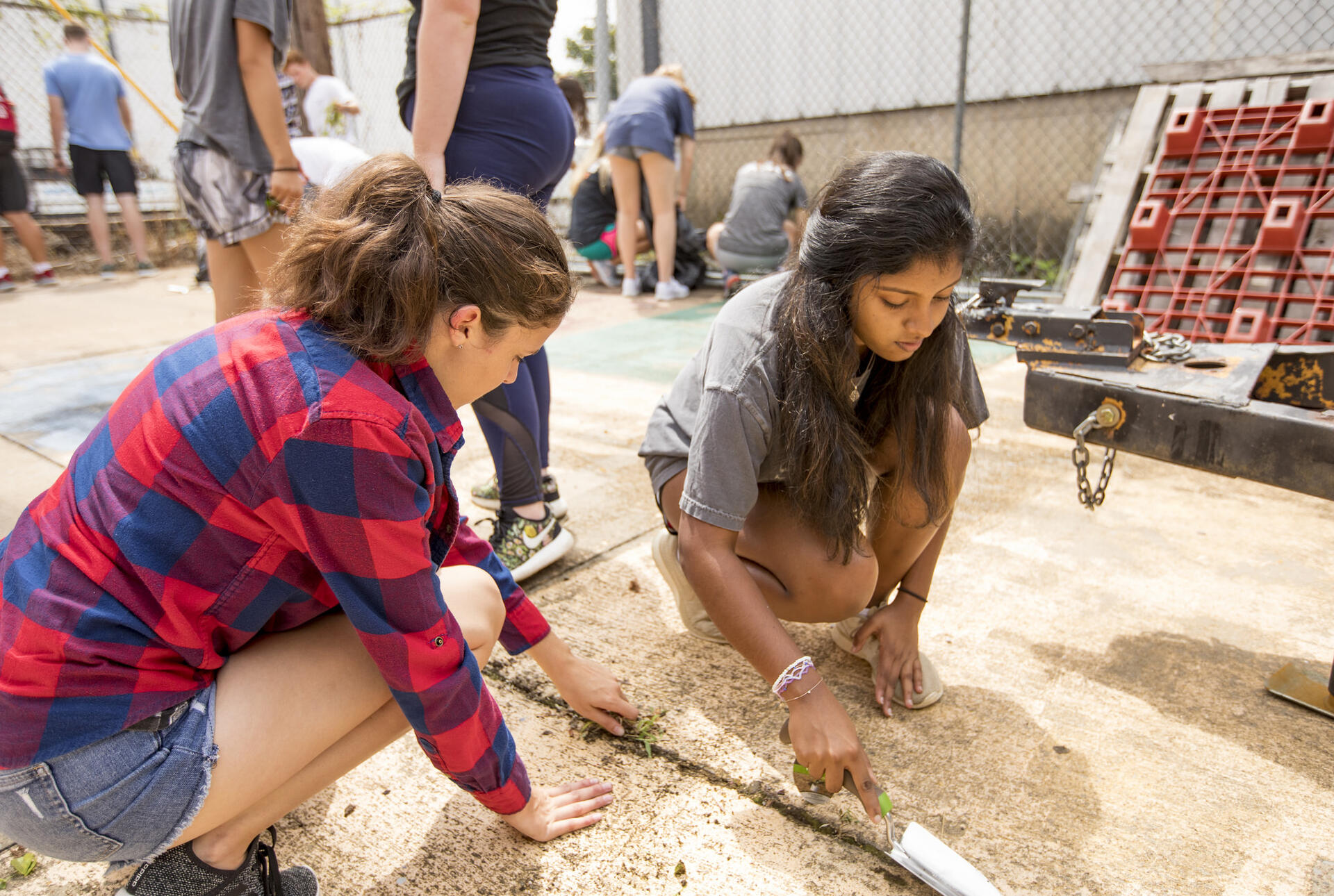 Two student crouched down fixing something not the ground