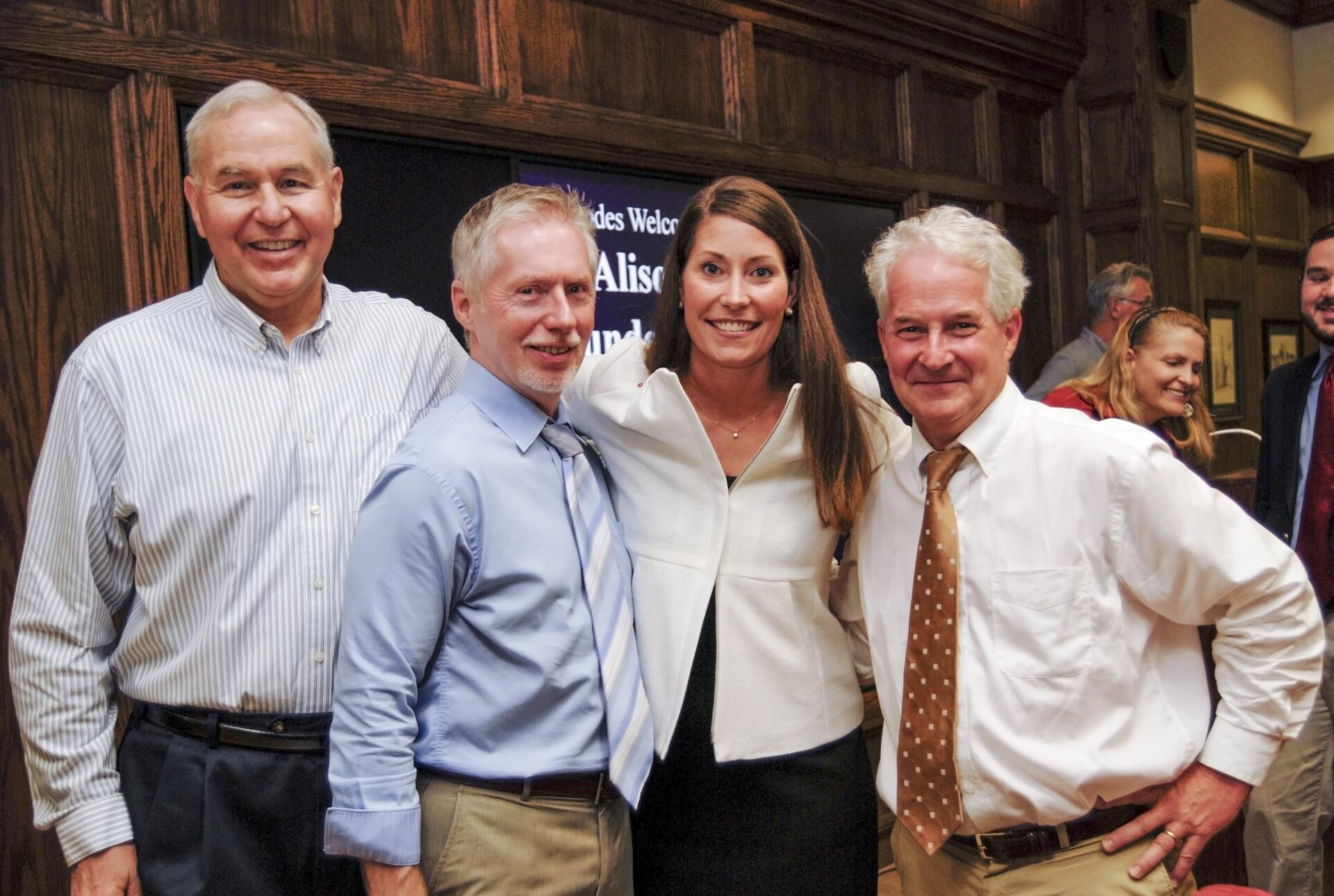 Three male professors with a young woman