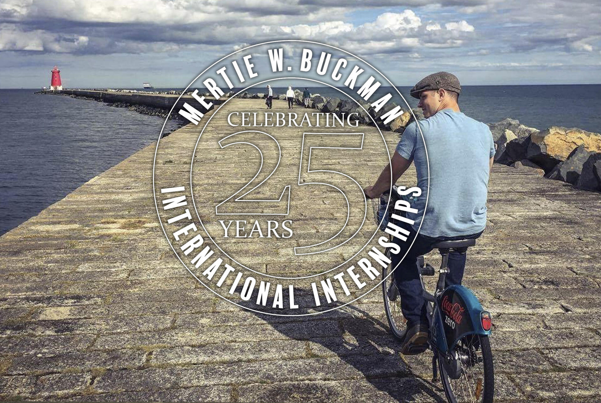 a young man bikes on a pier leading to the ocean