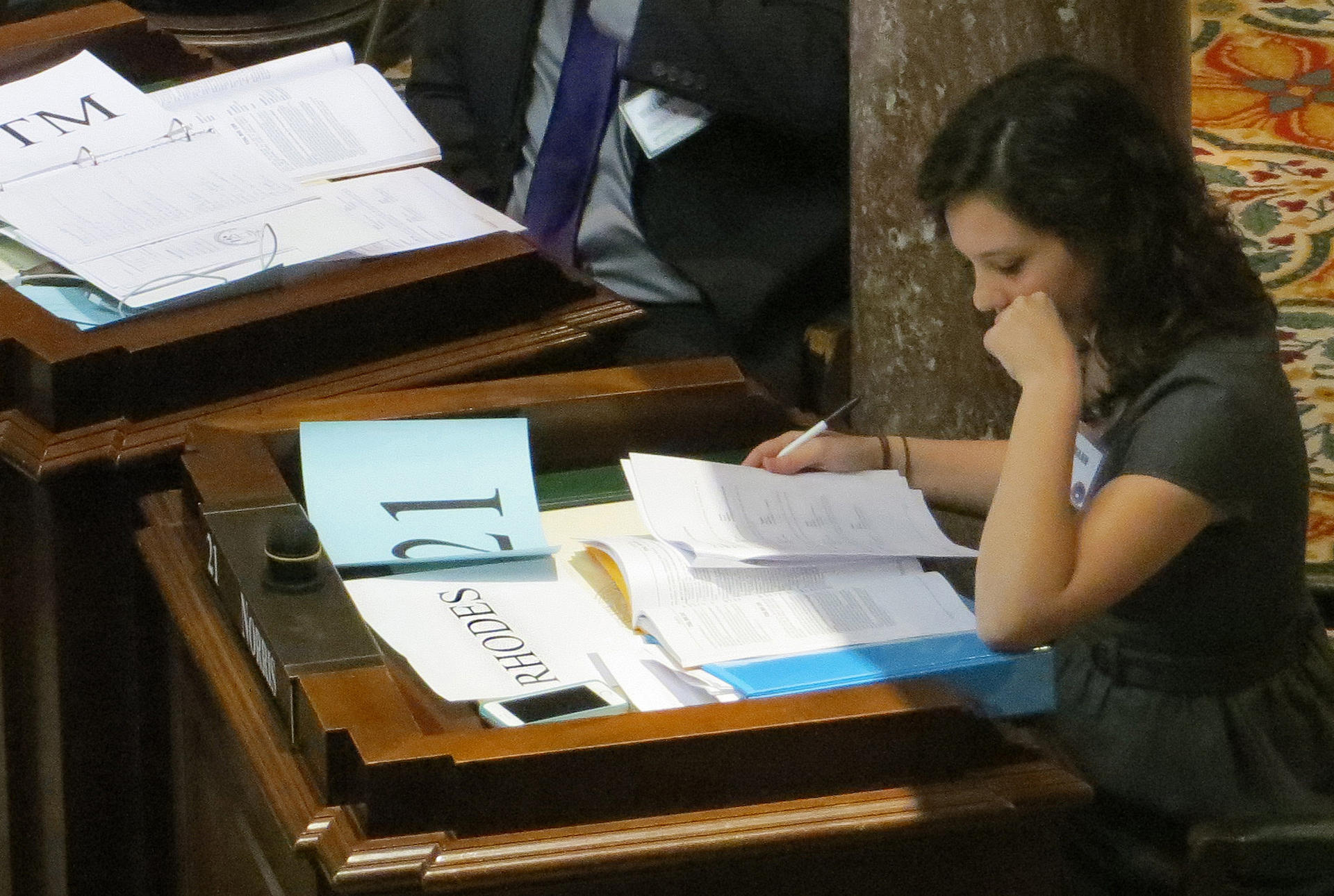a female student studies legislative papers at a desk