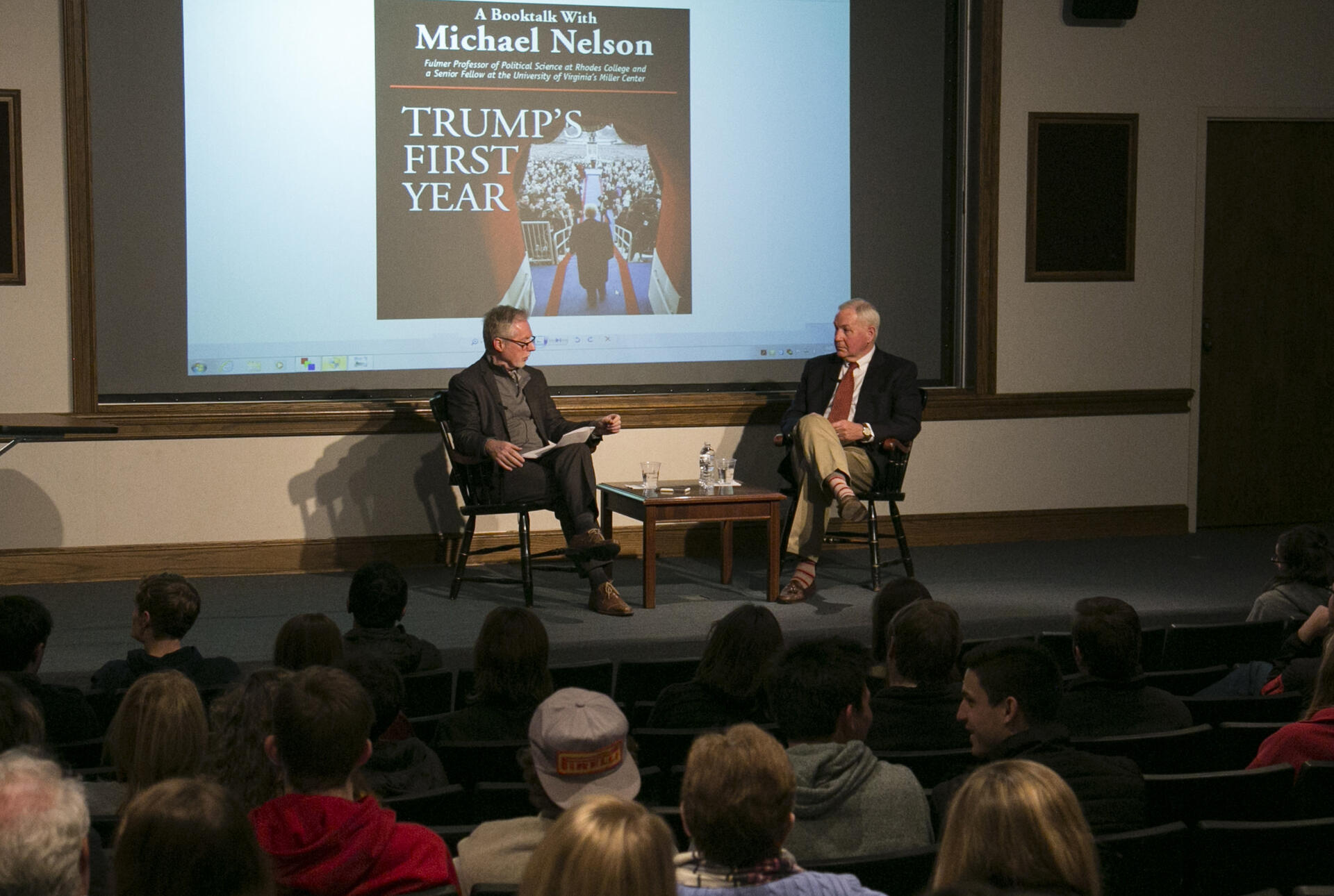 two professors talk on a stage