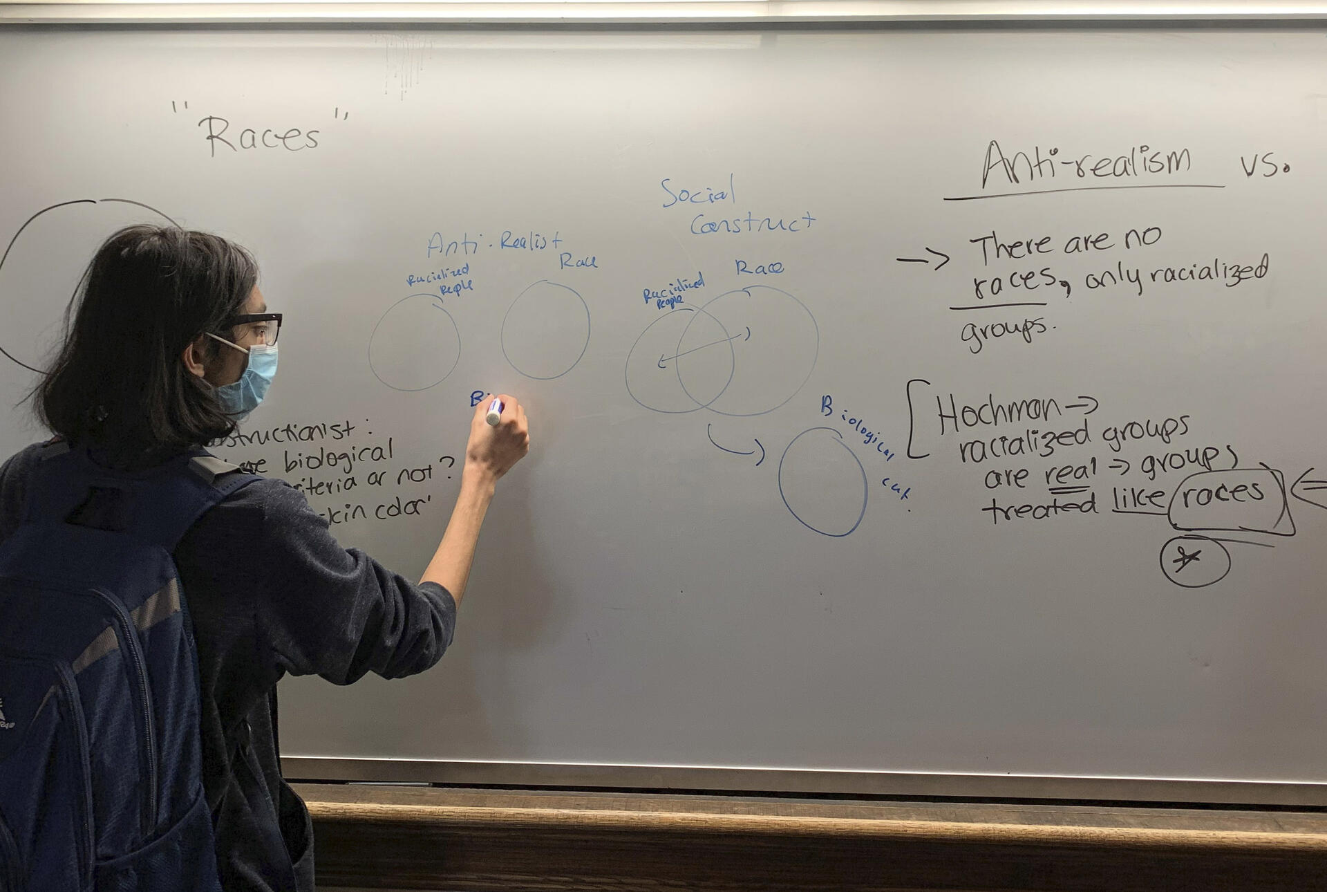 a student writes at the board