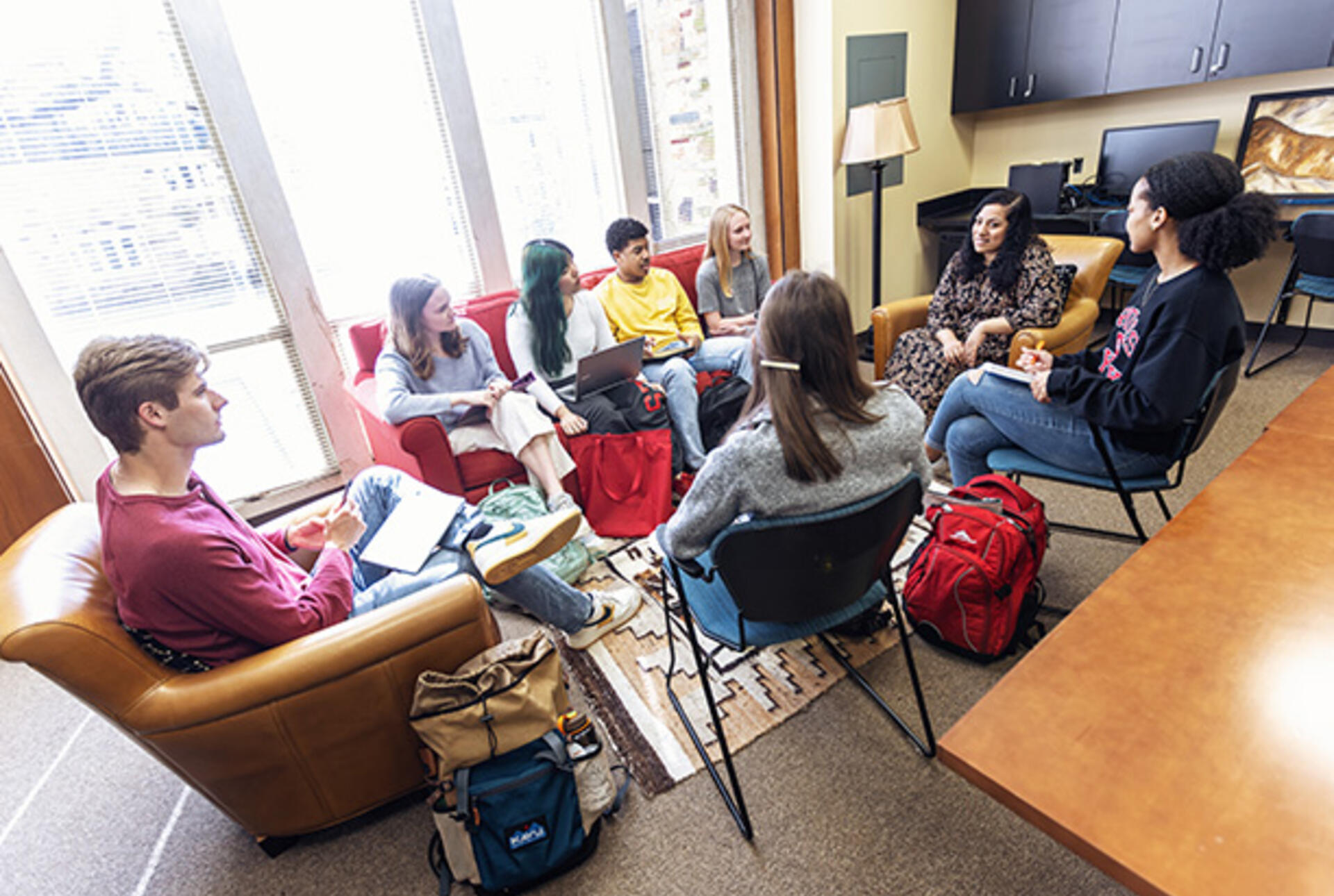 a female professor leads a discussion with a group of students