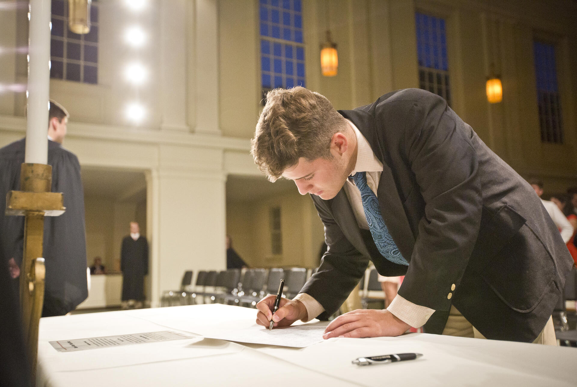 A young man signs the honor code.