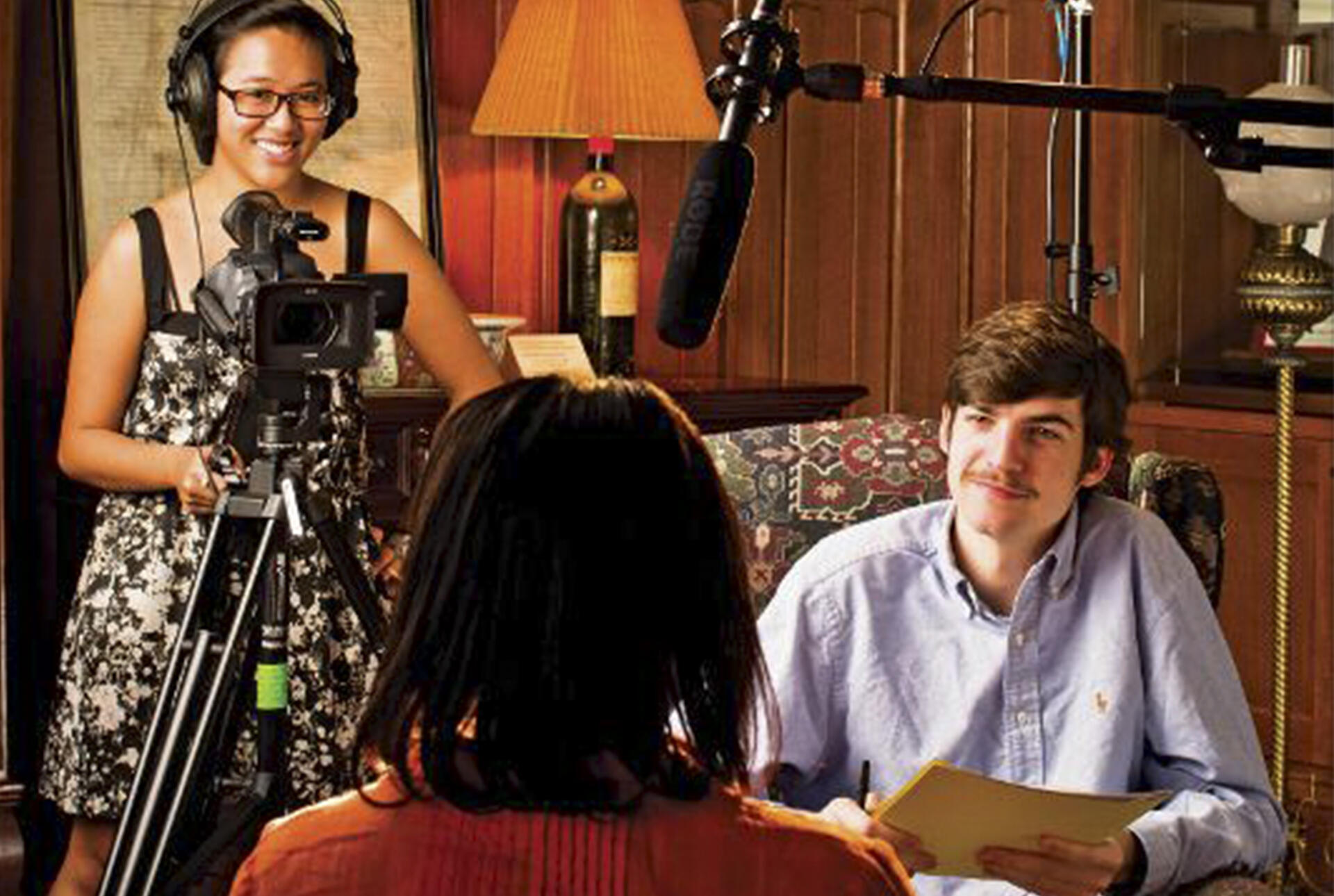 A man and woman interview a subject on camera.