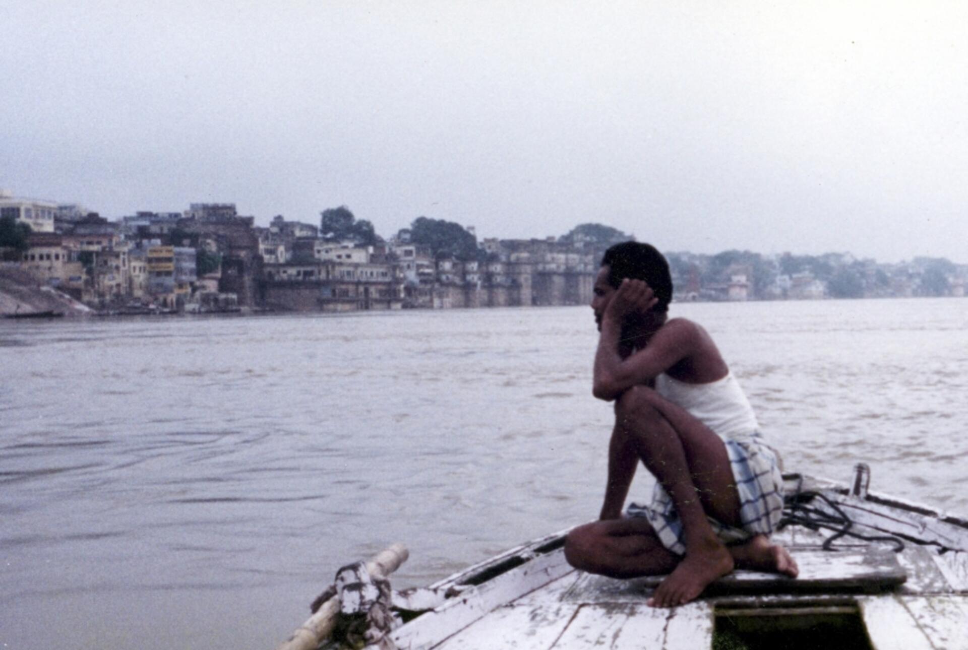 a student sitting by a lake
