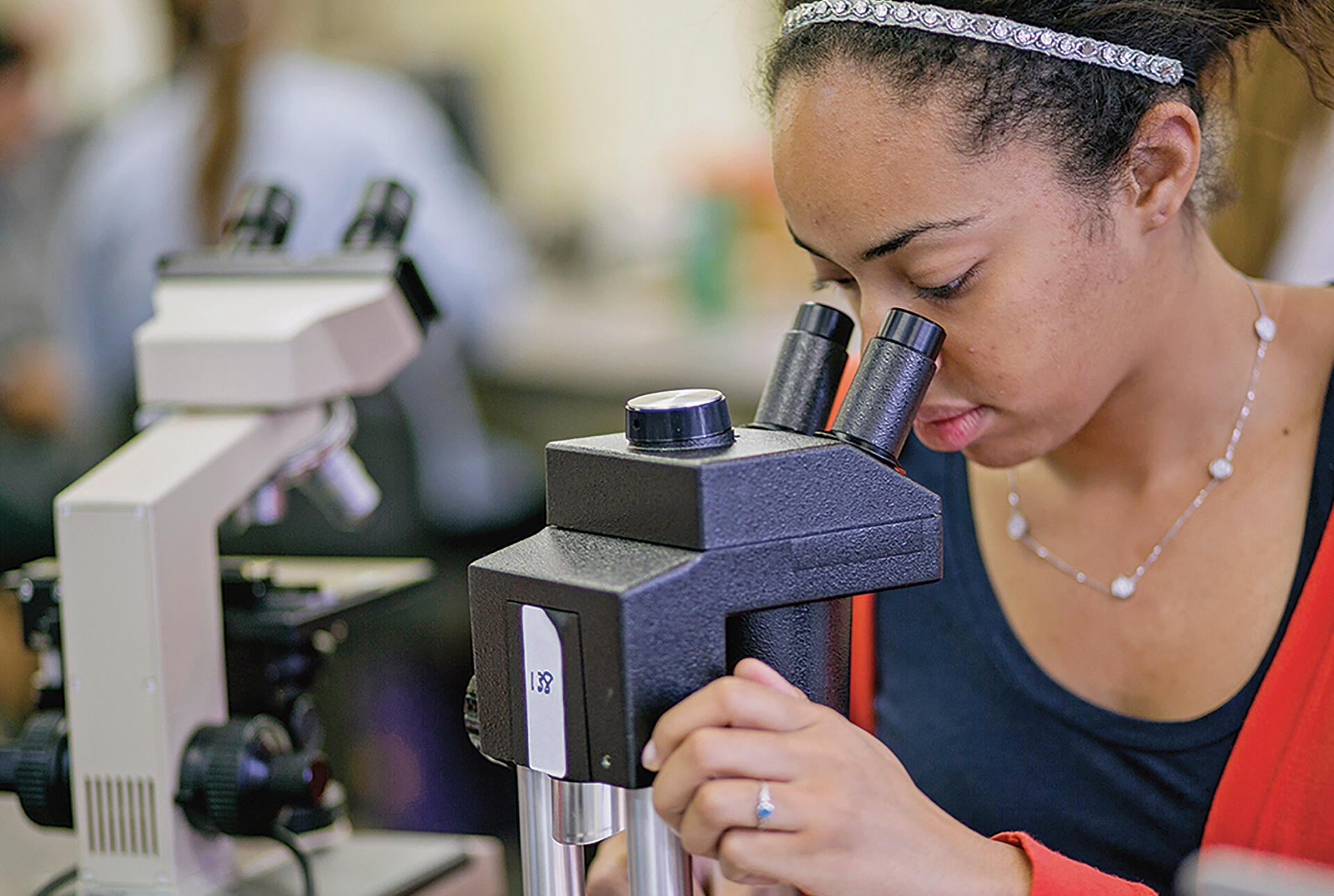 A student looks into a microscope