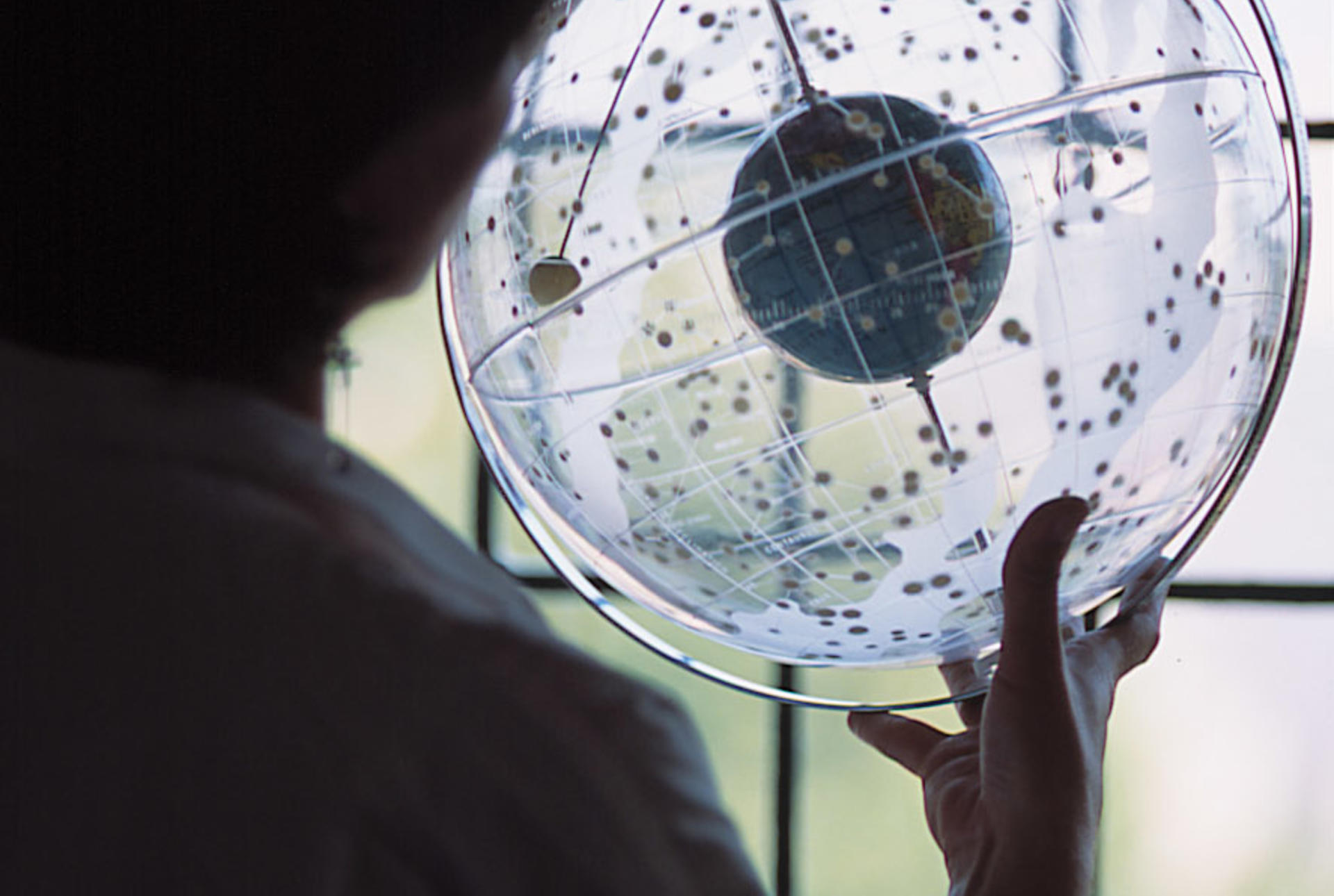 a student examining a clear globe