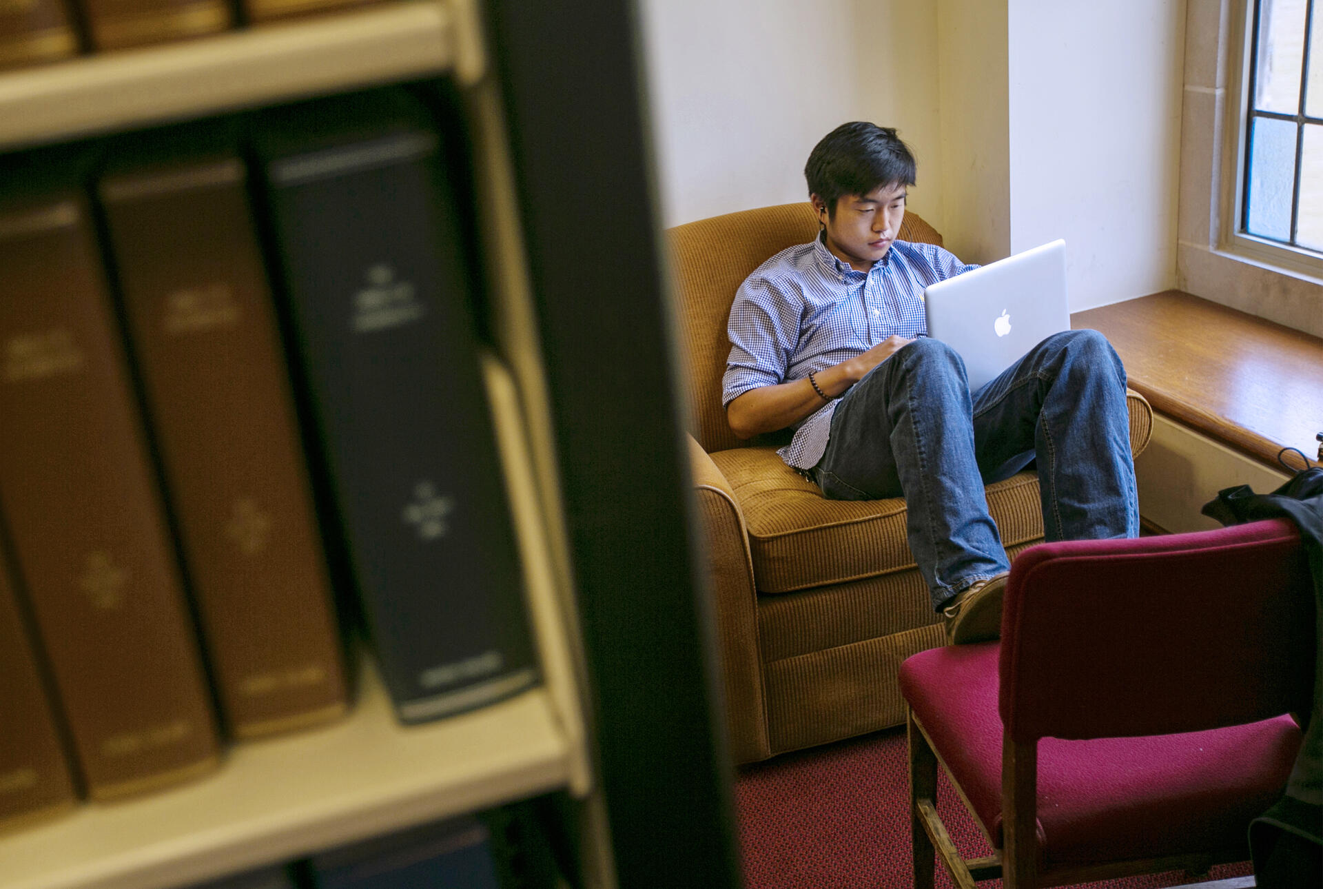 a student sitting with a laptop in the library
