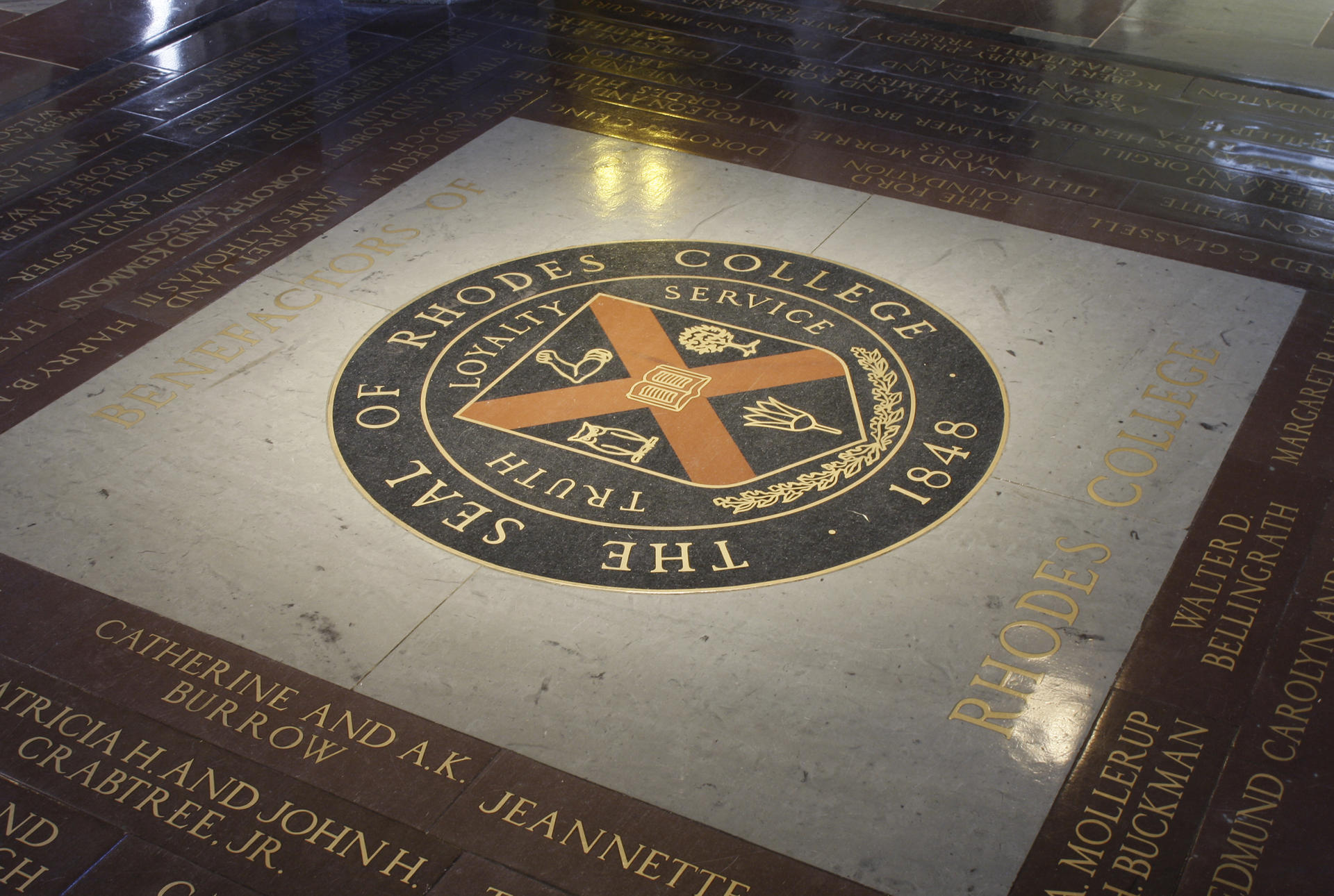 The seal of Rhodes College inlaid in the floor of Palmer Hall. If a student walk across it, the legend says that they will ever graduate