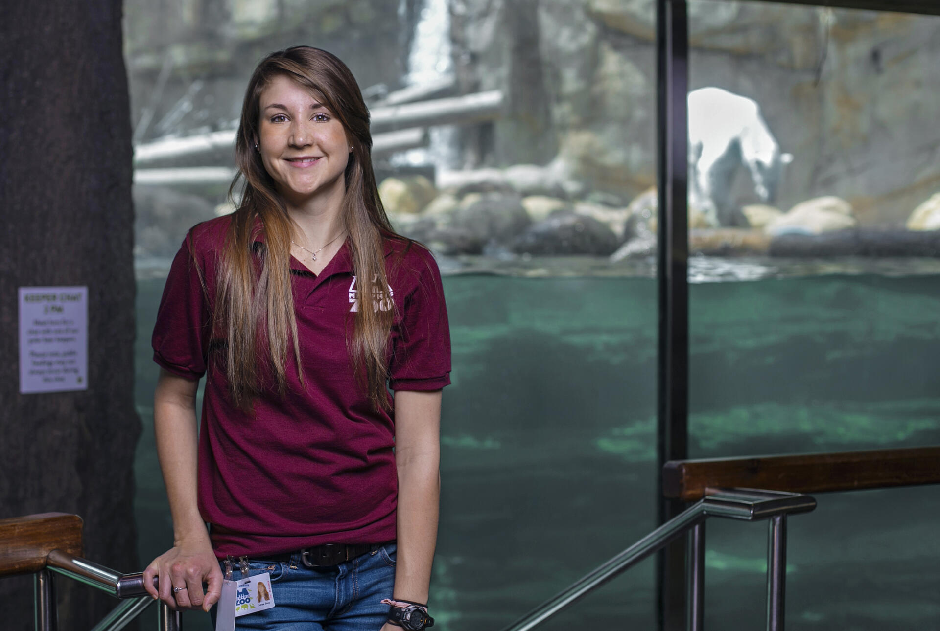 a student standing in front of an aquatic zoo exhibit