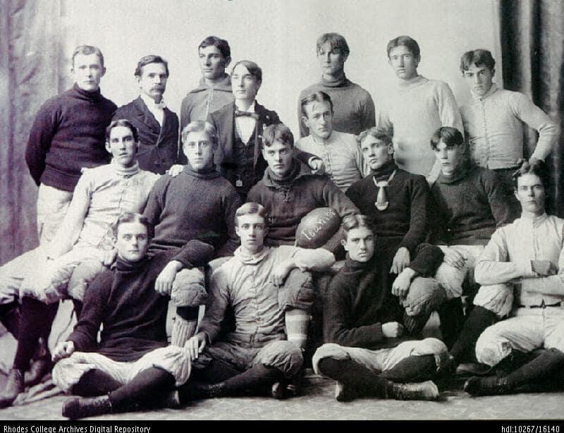 A black and white photo of a group of men in 19th century football attire
