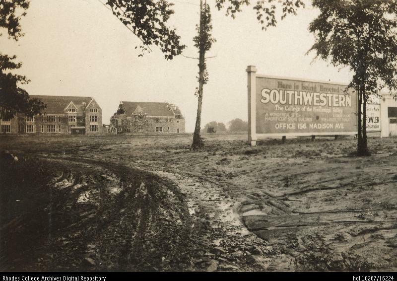 An old photo of a muddy construction site with a few buildings in the background and a sign in the middle ground that reads, "Here is being erected: Southwestern The College of the Mississippi Valley"