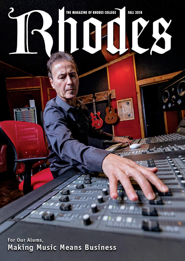 a man on the cover of Rhodes magazine works a sound board