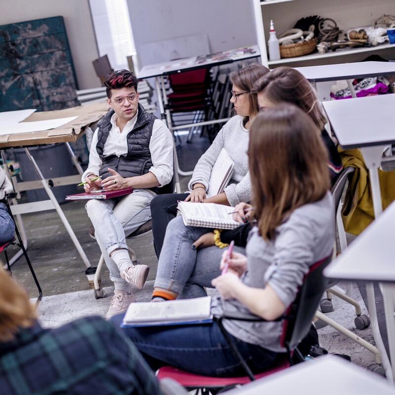 A professor seated with his students.