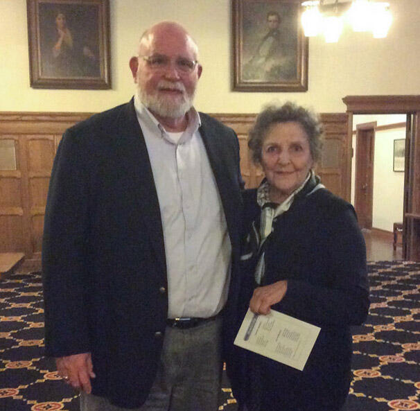 an older man with a beard and an older woman smile at the camers