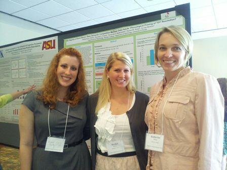 two female students stand next to a female professor with short hair