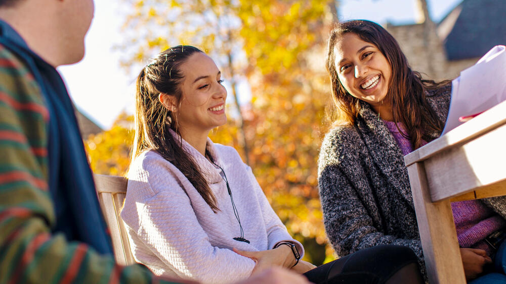 a group of students talk on campus