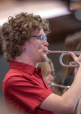 orchestra member playing a brass instrument