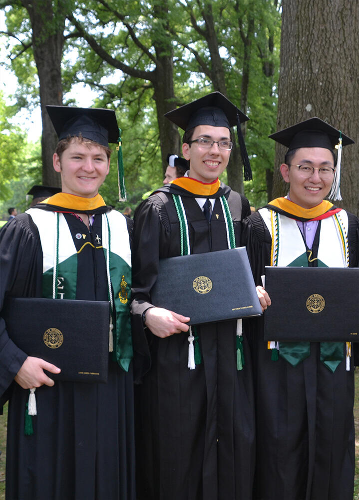 three male students in graduation robes