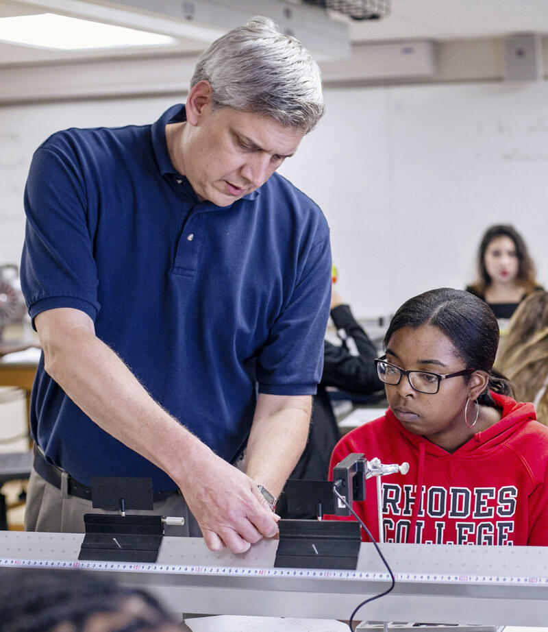 a male professor works with a physics student