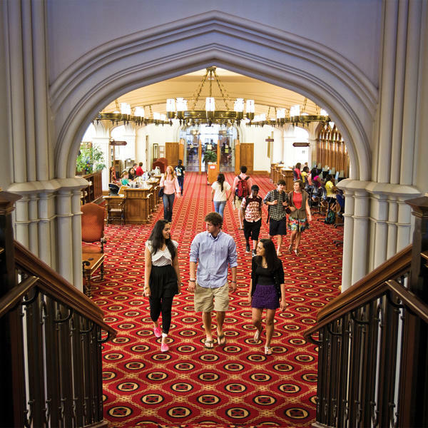 students walking toward stairs in a library