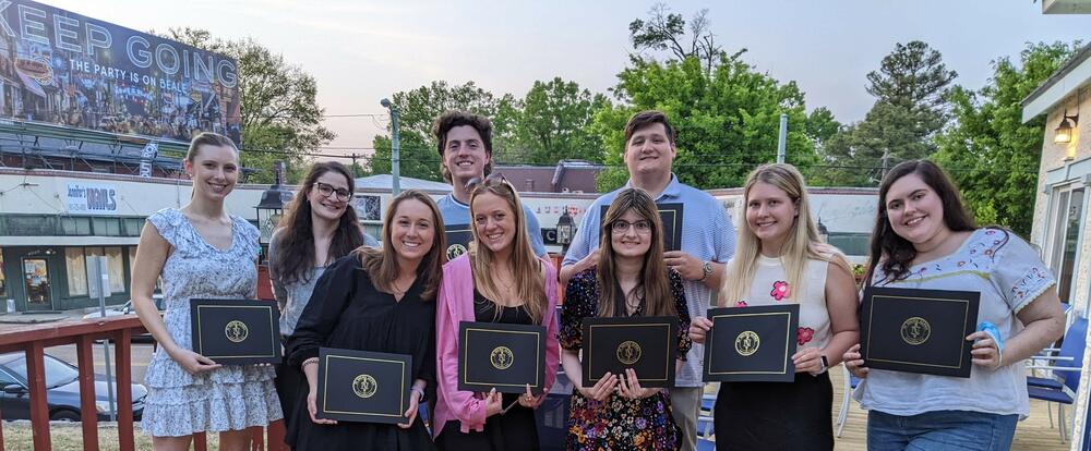 a group of students holding awards