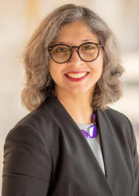 a woman with shoulder-length hair and glasses