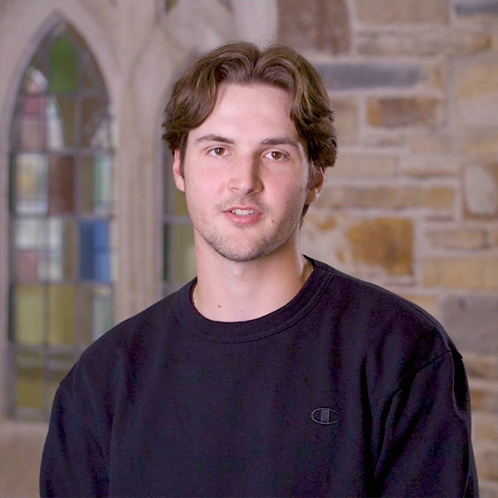 A young man in a gray sweatshirt.