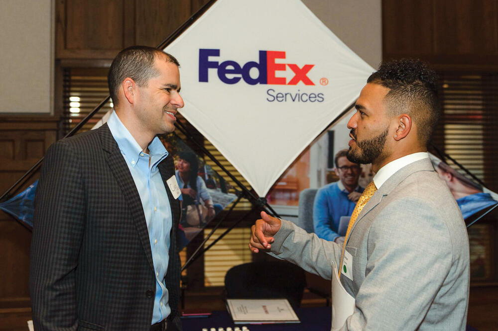 a young man talks with a representative at a career fair