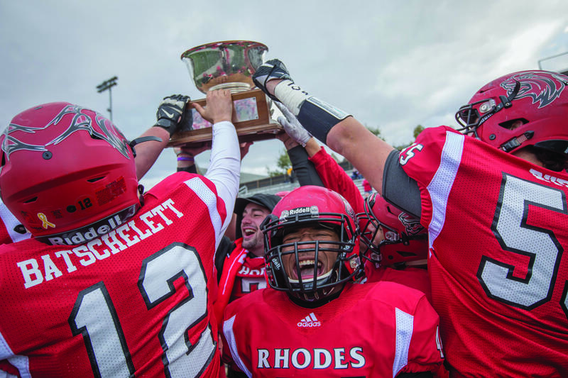 football players hold up a trophy