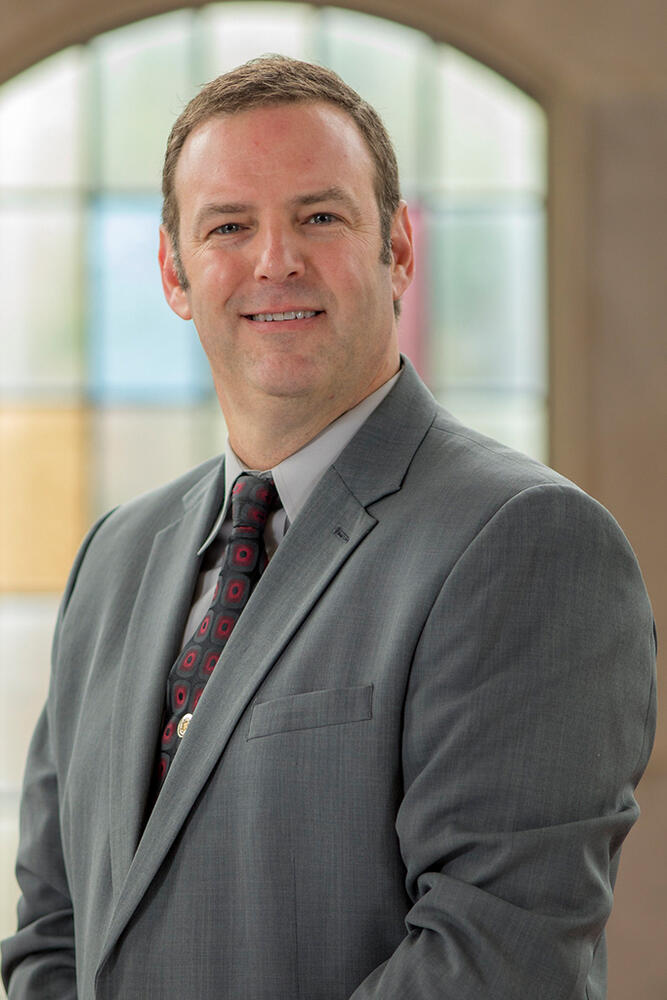 a man in a suit smiles at the camera