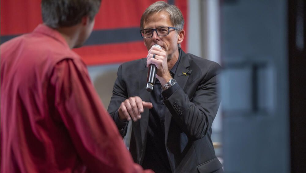  a man speaks into a microphone