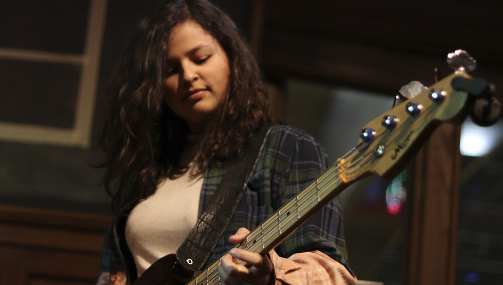 a young woman plays a guitar