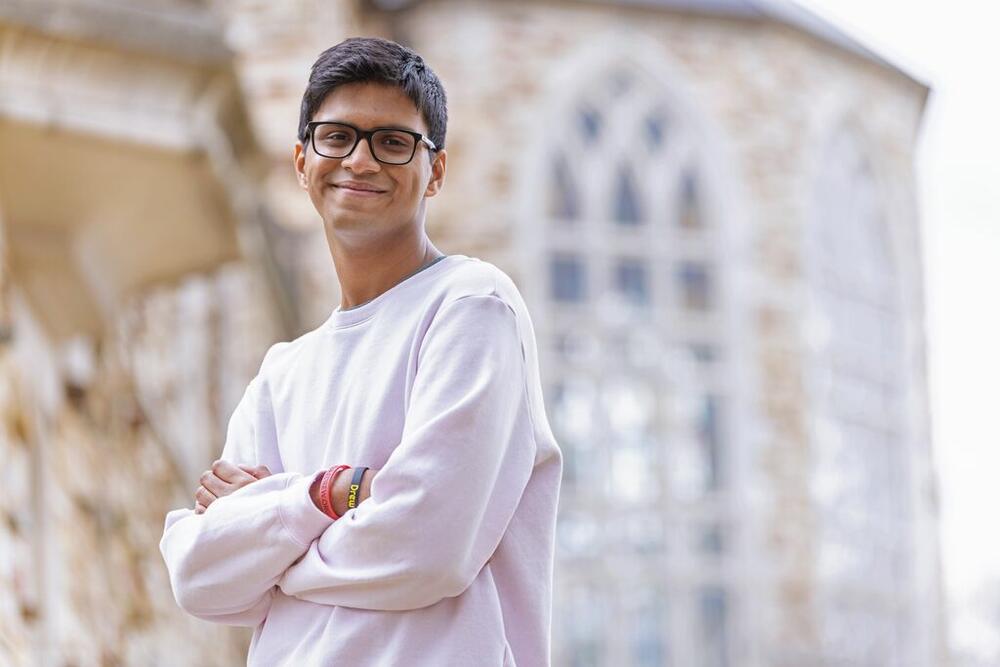 a young man from Kolkata, India, in front of a stone building