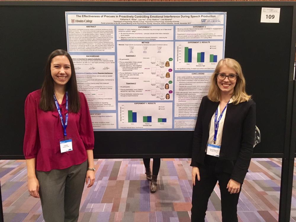 two young womenstand next to a poster board