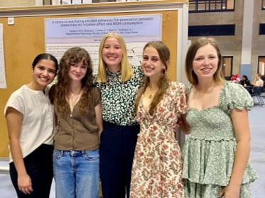 a group of students in front of a research poster