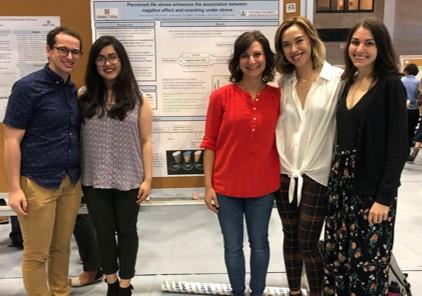 a group of students in front of a research poster