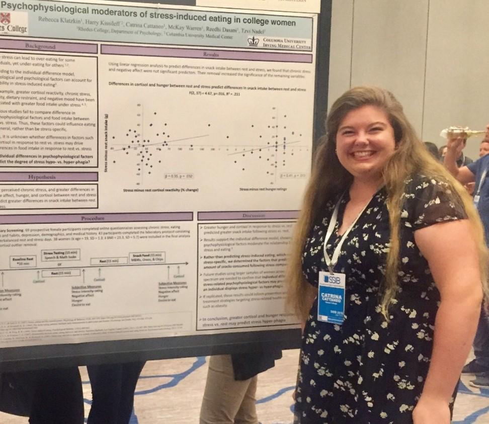 a student in front of a research poster