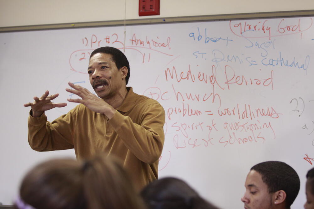 a male professor lectures before a class