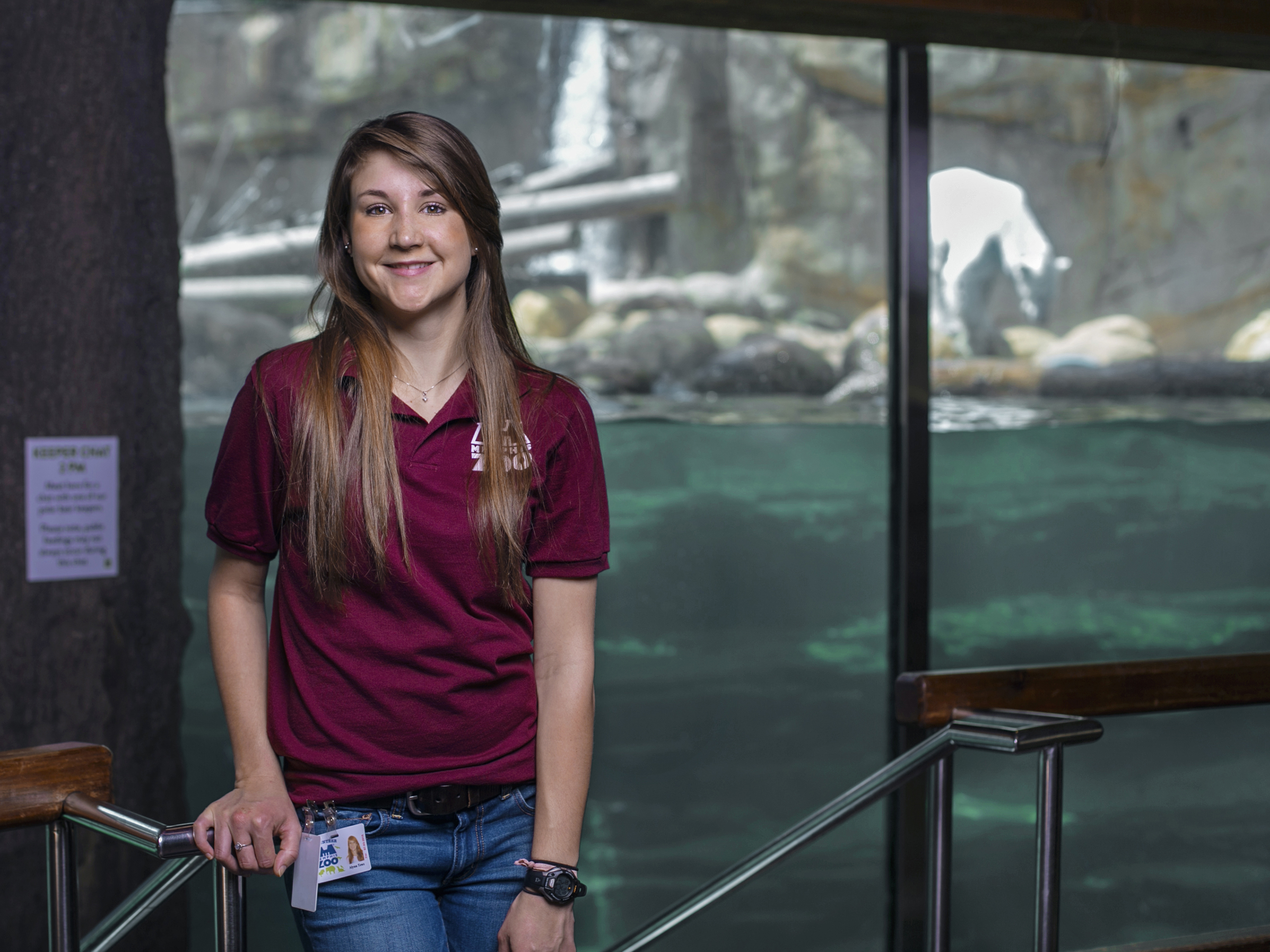 a student standing in front of an aquatic zoo exhibit