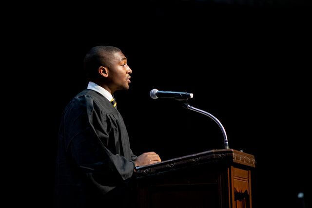 a young African American man speaks at a podium