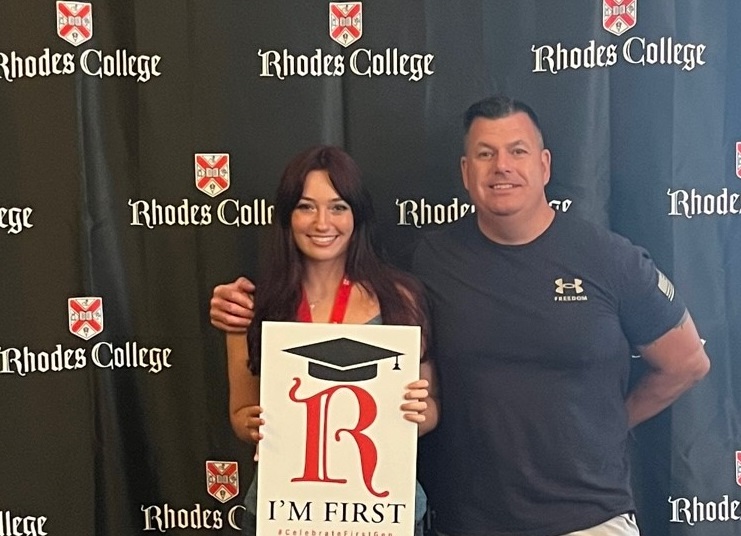 image of a Rhodes student holding an I'm First sign, standing next to a family member